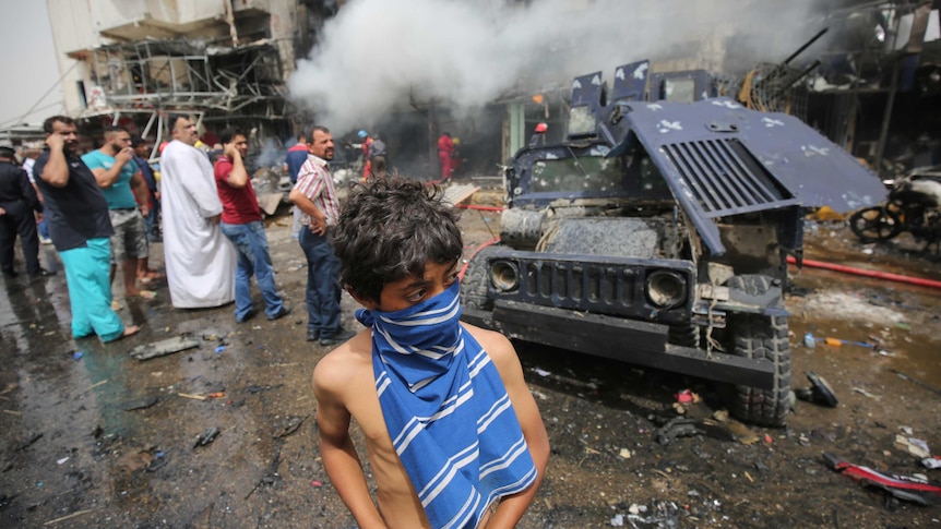 Iraqis check the scene of a car bomb attack in the mostly Shiite neighbourhood of Baghdad Jadida in Baghdad.