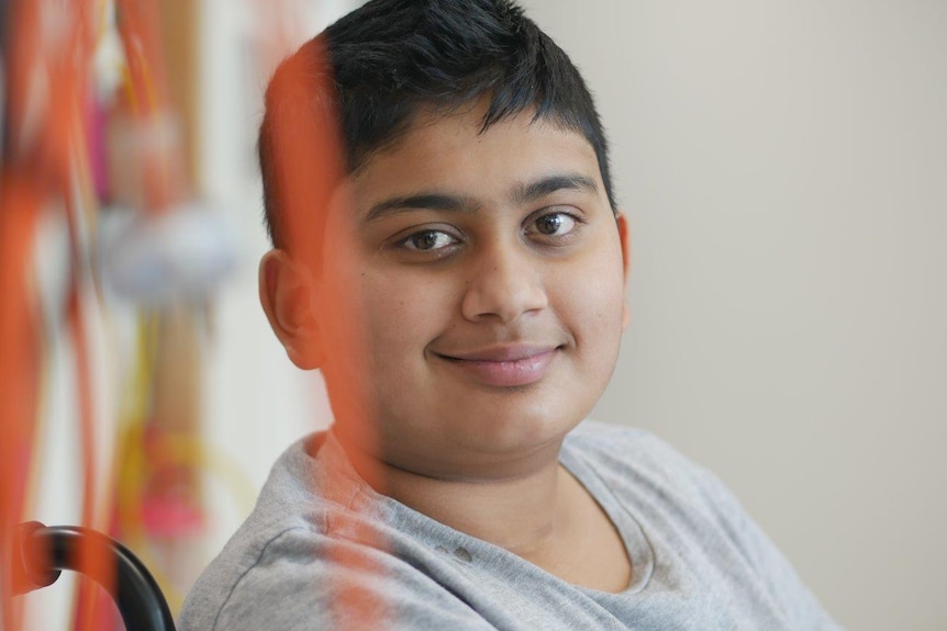 A head and shoulders photo of Vishal Pindoria sitting in a wheelchair and smiling.
