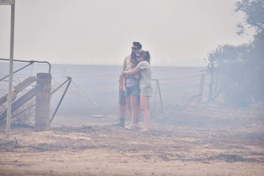 Residents watch as their house burns nearby