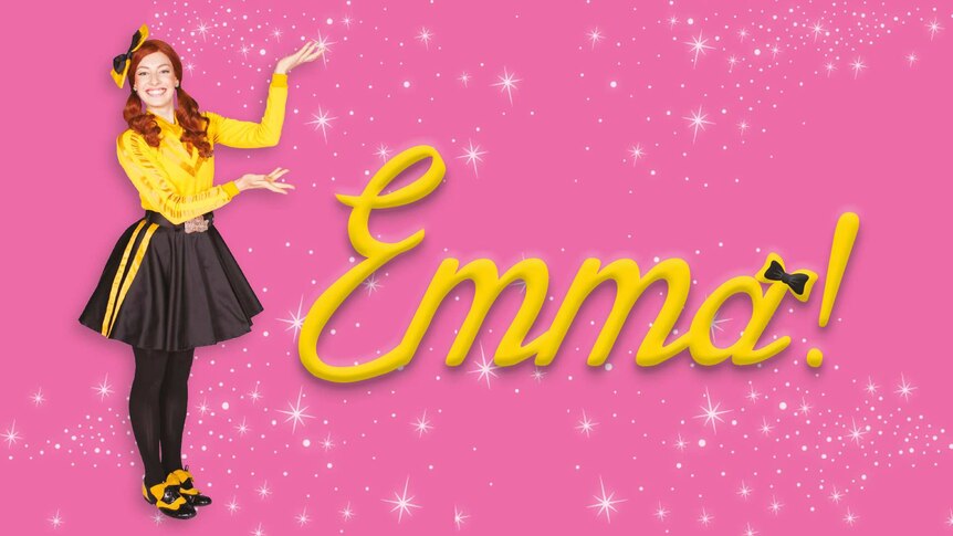 Emma Wiggle posing against a pink backdrop with numerous sparkles, her hand gesturing her name in bold lettering beside her