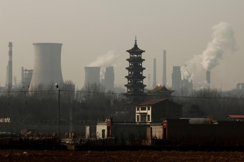 Cooling towers emit steam and chimneys billow in an industrial zone in Wu'an, Hebei province, China