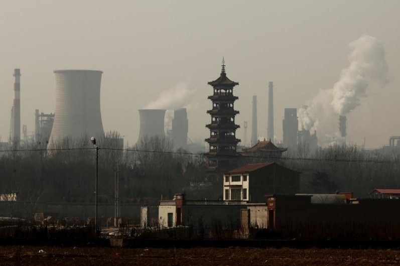 Les tours de refroidissement émettent de la vapeur et des cheminées s'élèvent dans une zone industrielle à Wu'an, province du Hebei, Chine