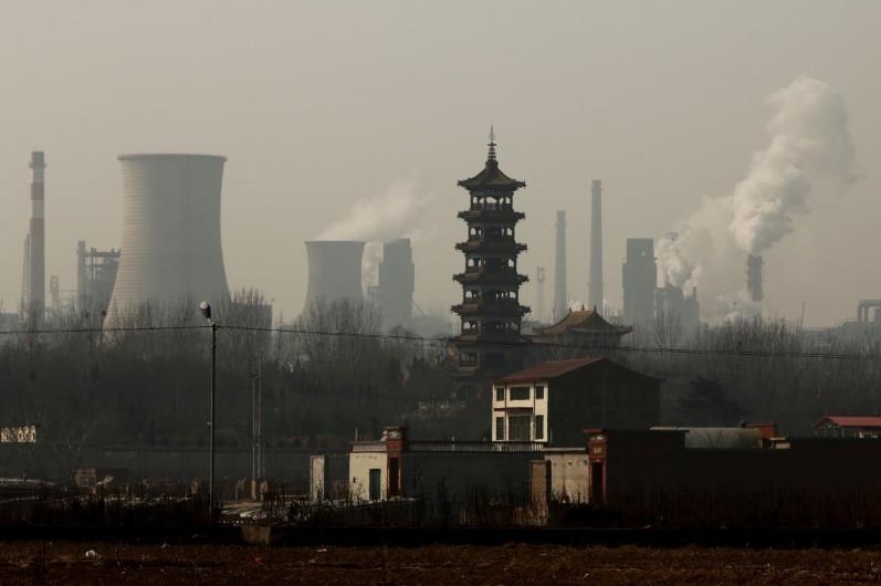 Cooling towers emit steam and chimneys billow in an industrial zone in Wu'an, Hebei province, China