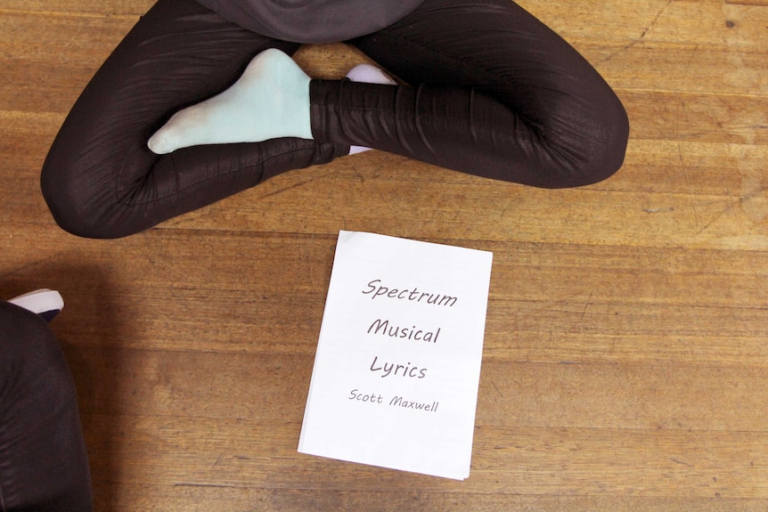 Student sitting with musical score lying on the floor