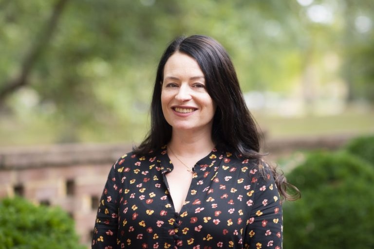 Portrait photo of a dark-haired woman with natural background