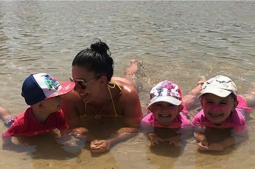 Hannah Clarke, also known as Hannah Baxter, with her three children at the beach, laying on stomachs.
