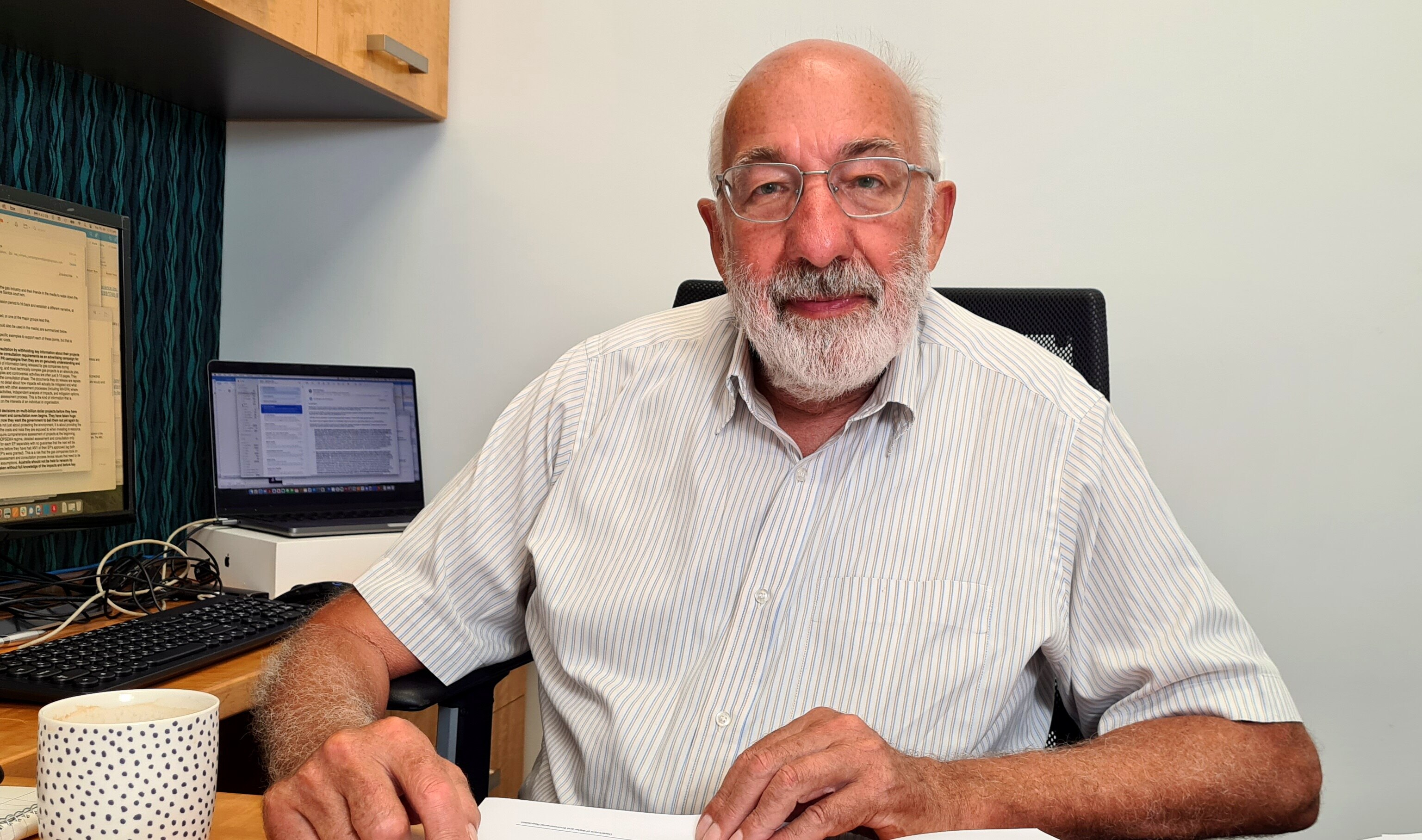 A man sits at his desk. 
