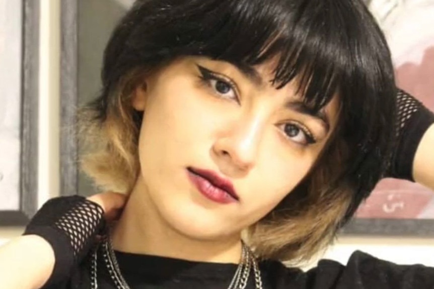 An Iranian girl posing with short hair and a black T-shirt.