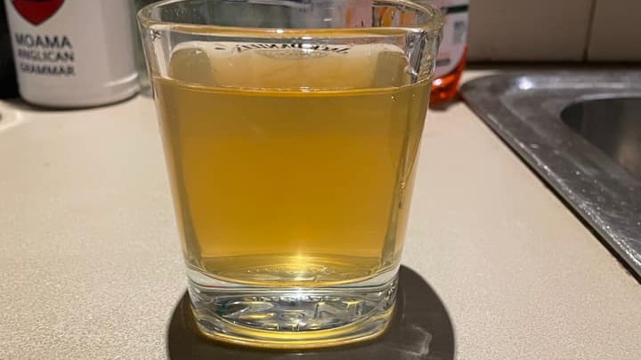 a glass of brown water sits on a counter top