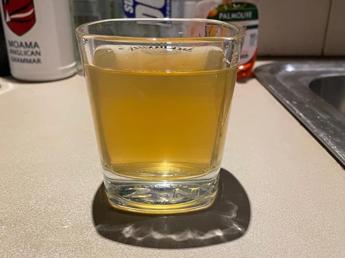 a glass of brown water sits on a counter top