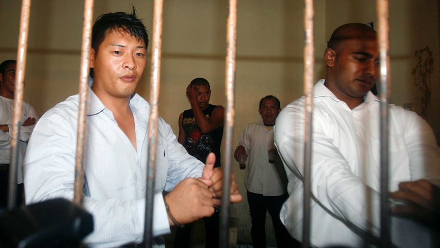 Andrew Chan and Myuran Sukumaran wait behind bars in a temporary cell