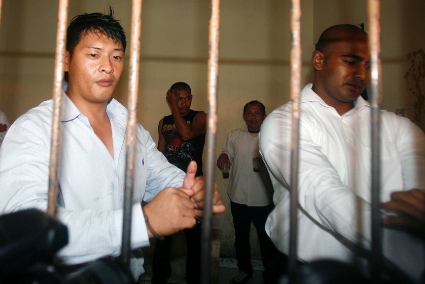 Andrew Chan and Myuran Sukumaran wait behind bars in a temporary cell