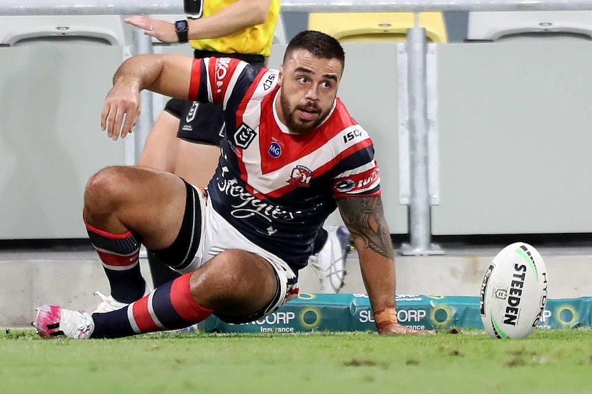 A Sydney Roosters NRL player gets up off the ground after scoring a try against the North Queensland Cowboys.