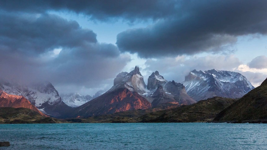 Snow-capped mountains behind a lake.