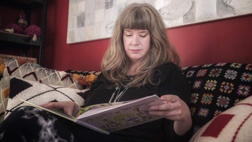 Kate the life long renter reading a book a couch, May 2019.