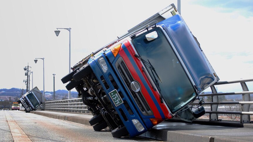 Wind gets the better of two trucks in Toyama City, Japan.