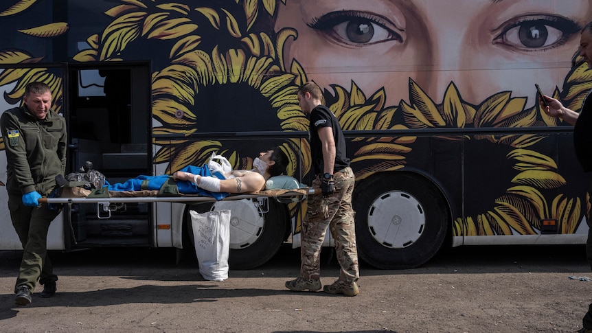 A man carried in front of a bus. 