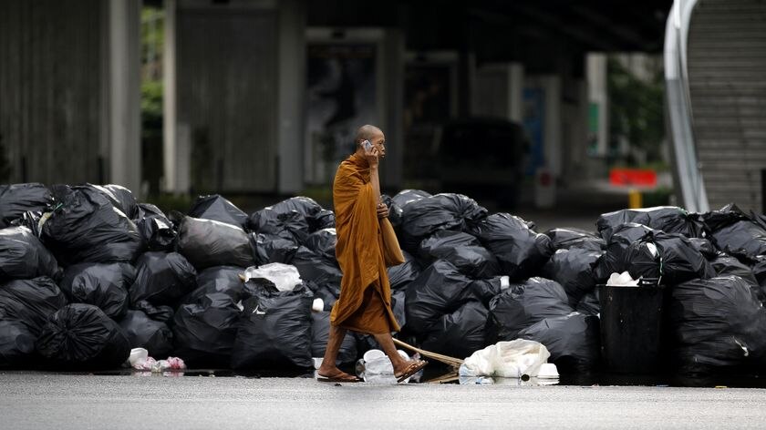 A Buddhist monk walks past a barricade