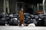 A Buddhist monk walks past a barricade