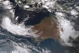 Satellite image of Australia: east coast covered in cloud, band of could swirling into the west coast