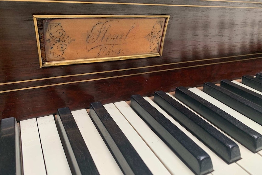 Original brass Pleyel nameplate on piano keyboard.