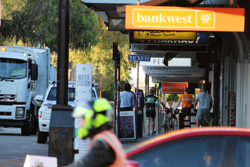 Cyclists and pedestrians line-up to order a coffee on a neighbourhood cafe strip