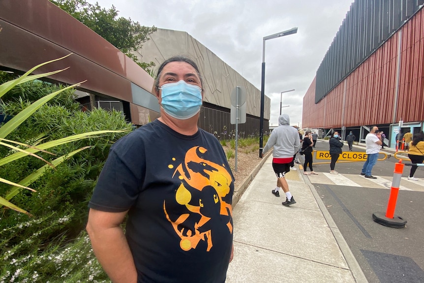 Mira smiles, wearing a surgical mask, as she stands outside Sunshine Hospital.