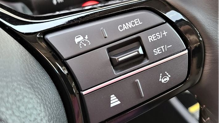 Close up of vehicle cruise control features on steering wheel