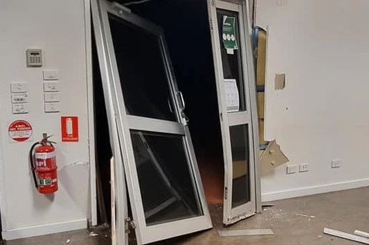 Photo of front door smashed in at a premises.