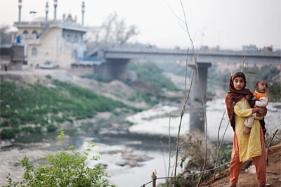 A girl holds a baby on March 17 in Rawalpindi, Pakistan, where a suicide bomber killed at least 10 people in a restaurant, a ...