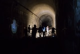 Media tour group examine graffiti in the St James station disused tunnel