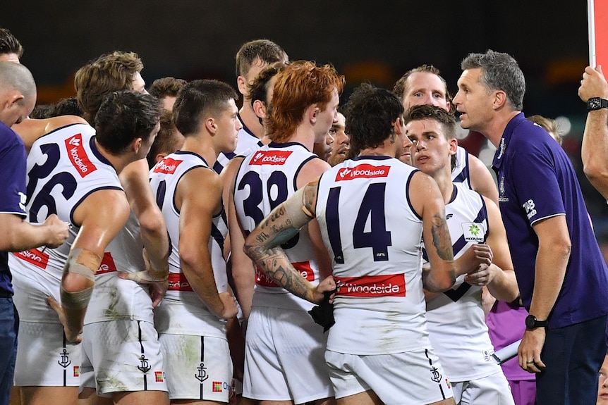 Justin Longmuir, coach of the Fremantle Dockers, addresses a groupd of players during an AFL game