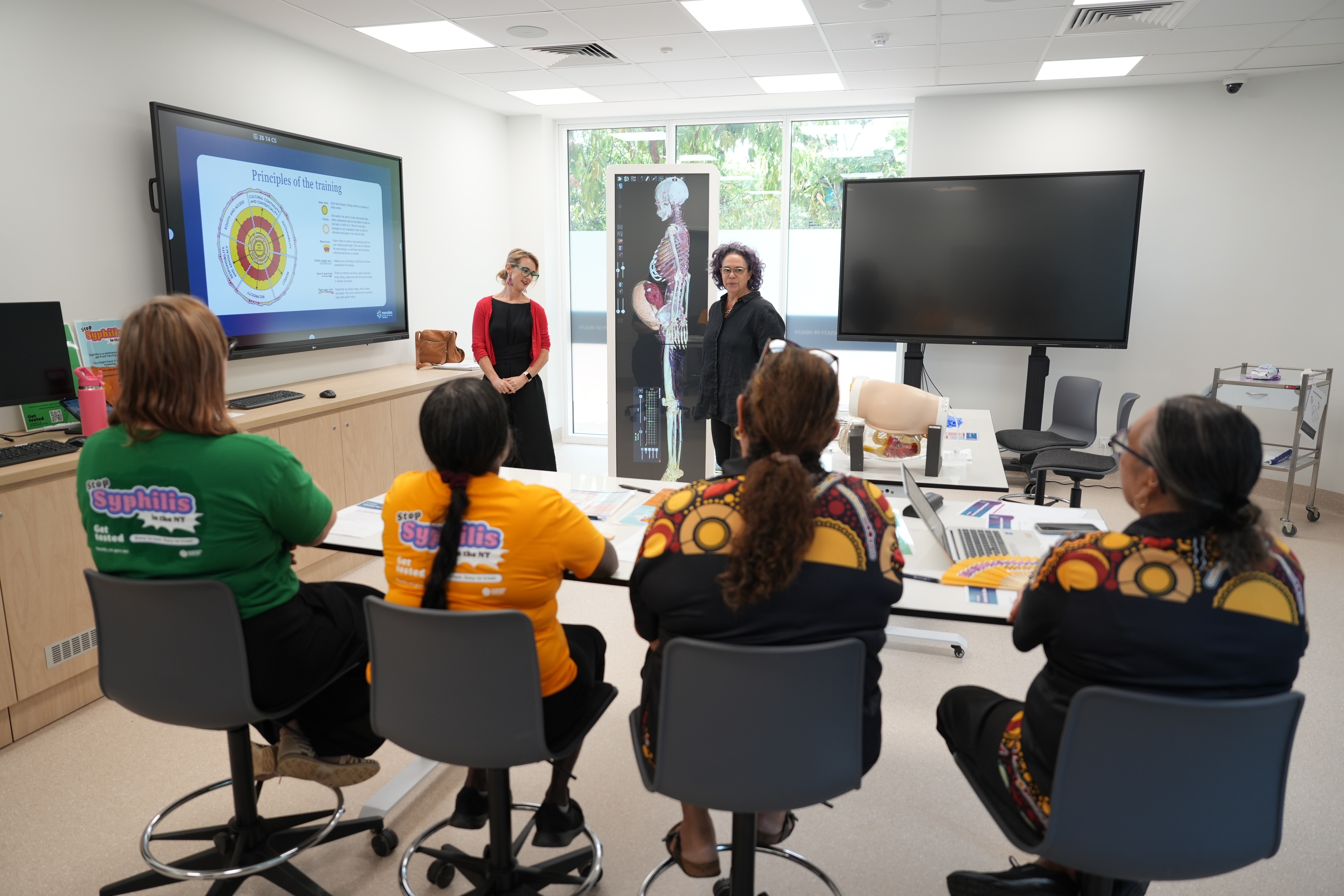 A small group of healthcare workers looking at a screen as part of a training session.
