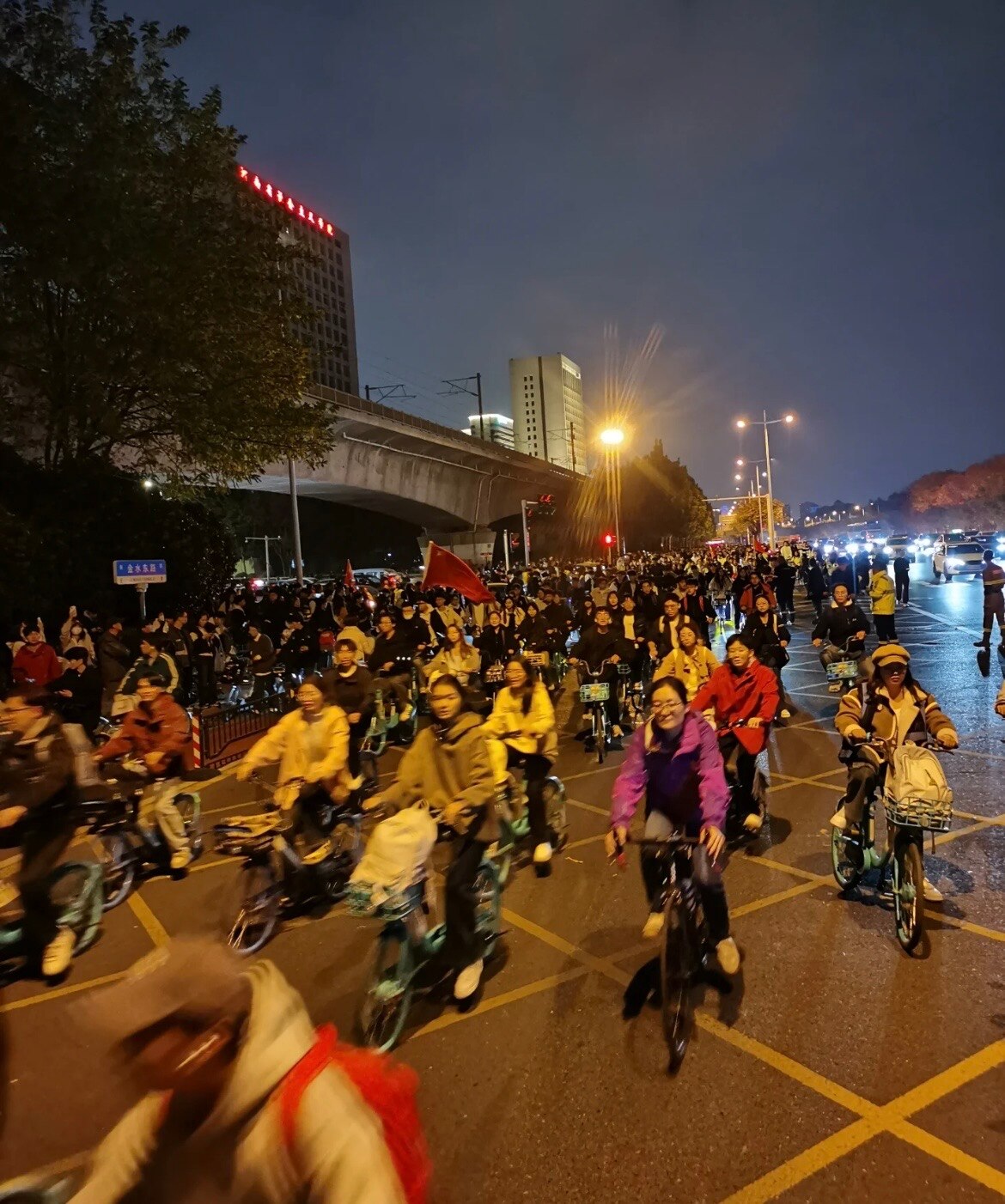 中国人の自転車選手が笑顔でカメラに向かって自転車に向かって走っています。