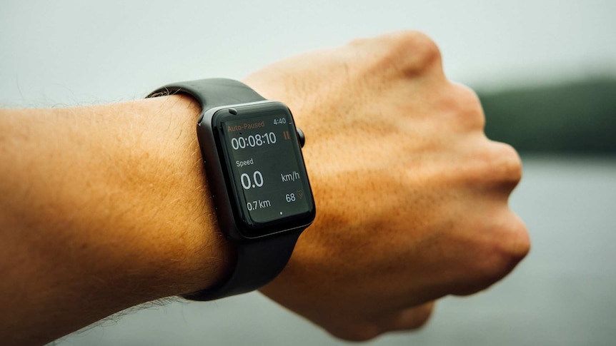 Close-up of a smart watch with a fitness app on someone's wrist.