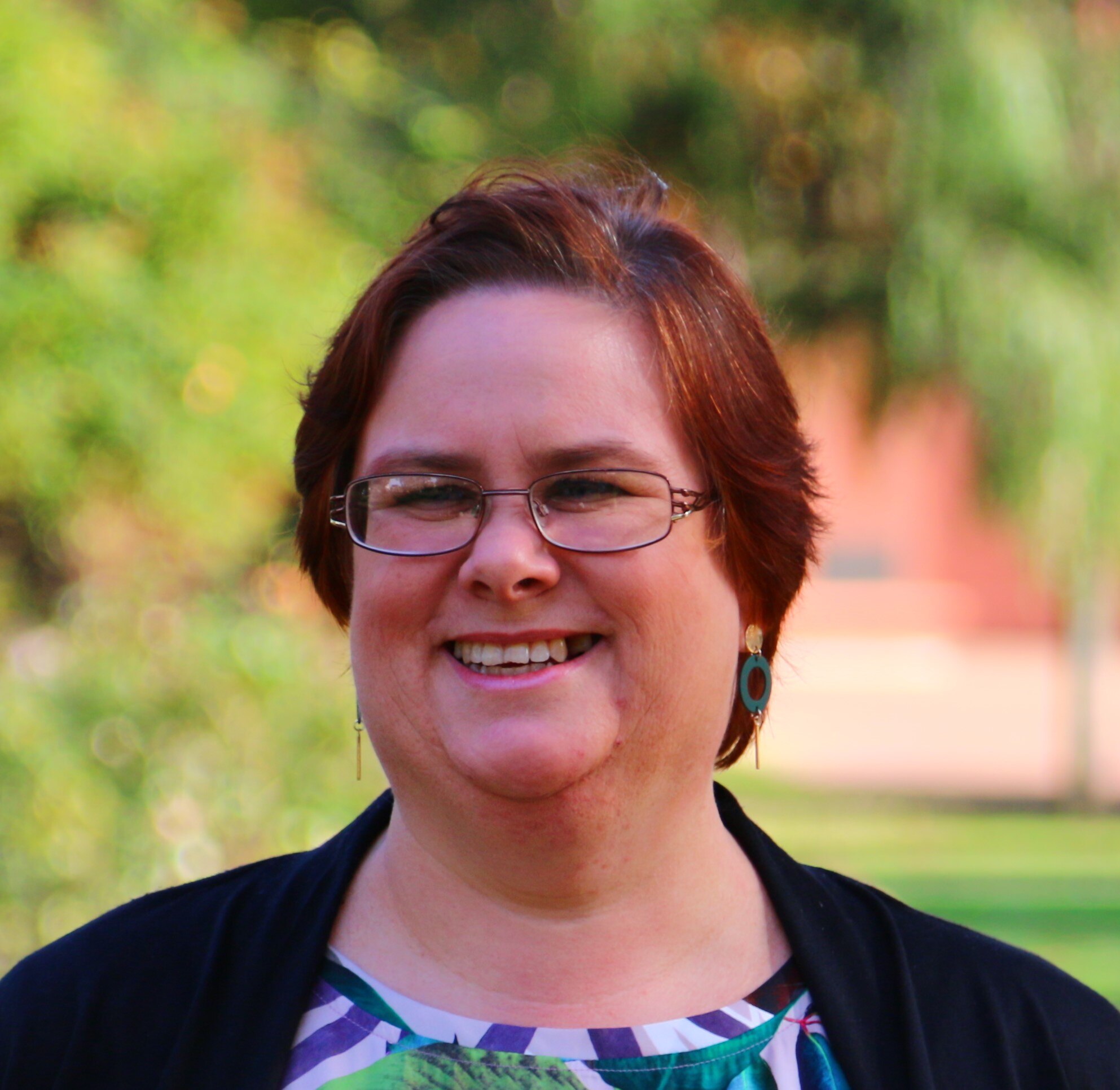 A close up photograph of a woman with glasses.