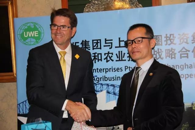 Two men shake hands while exchanging gifts.