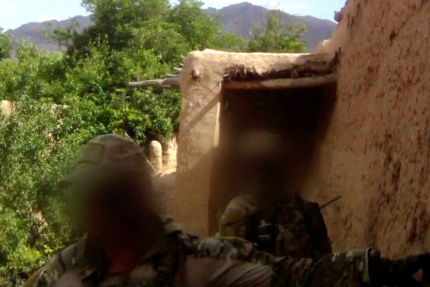 Two uniformed soldiers with blurred out faces.