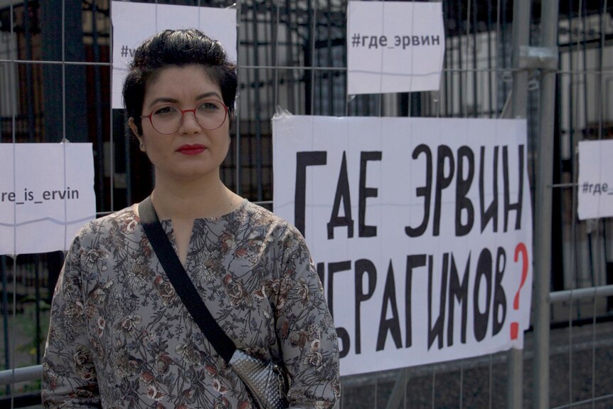 Crimean Tatar advocate Tamila Tasheva standing in front of Ukrainian signs.