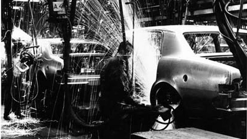 A welder works on a holder in a production line