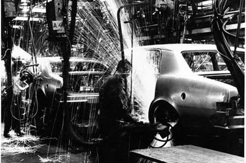 A welder works on a holder in a production line