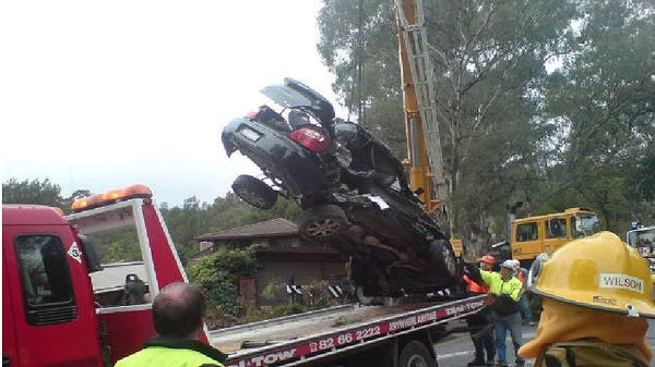 A wrecked car is moved after it was hit by a runaway quarry truck