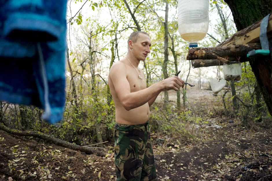A Ukrainian marine shaves at an improvised shower, less than a kilometre from pro-Russian separatists.