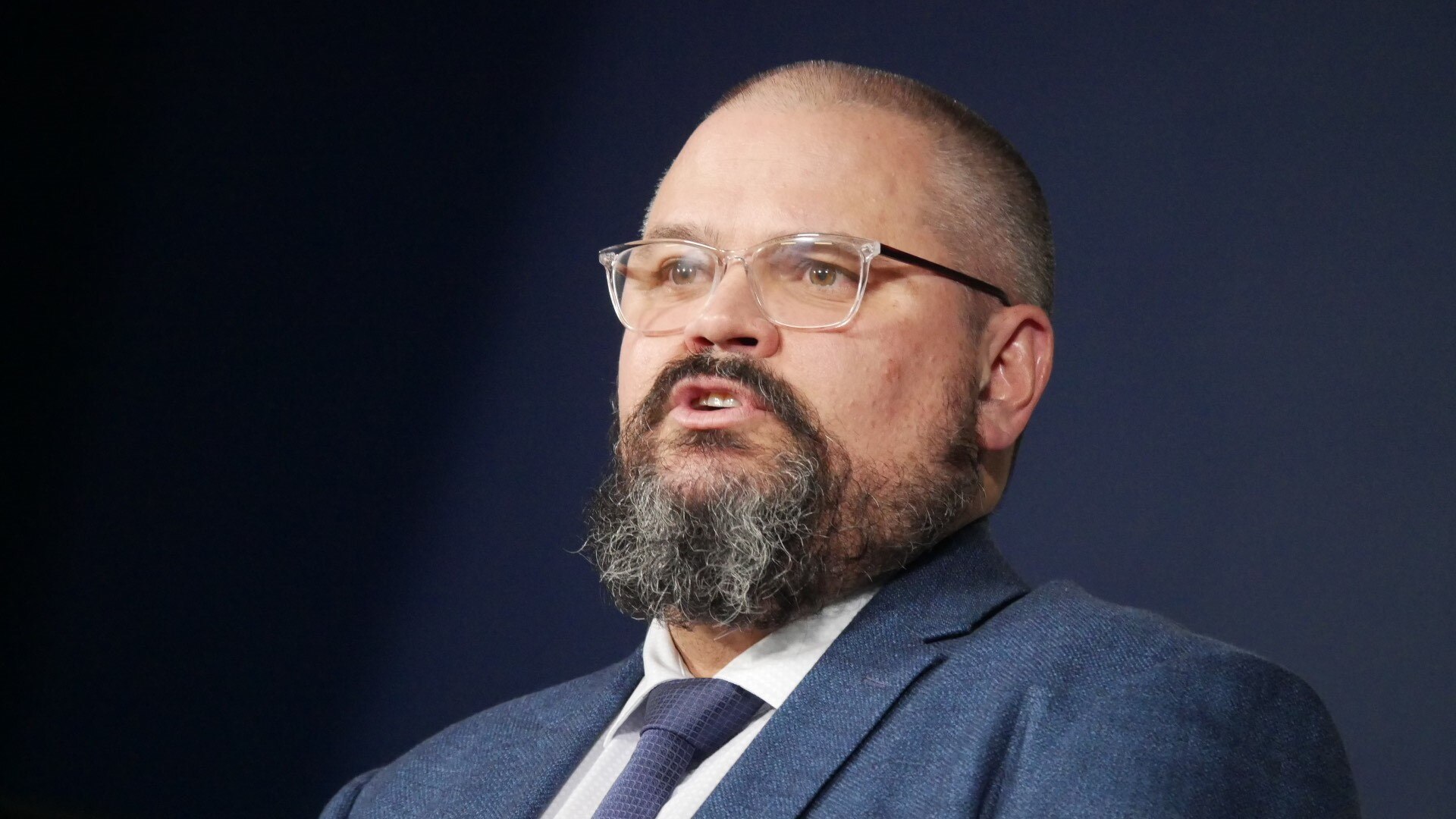 Tony Fleming in a suit speaks to media.