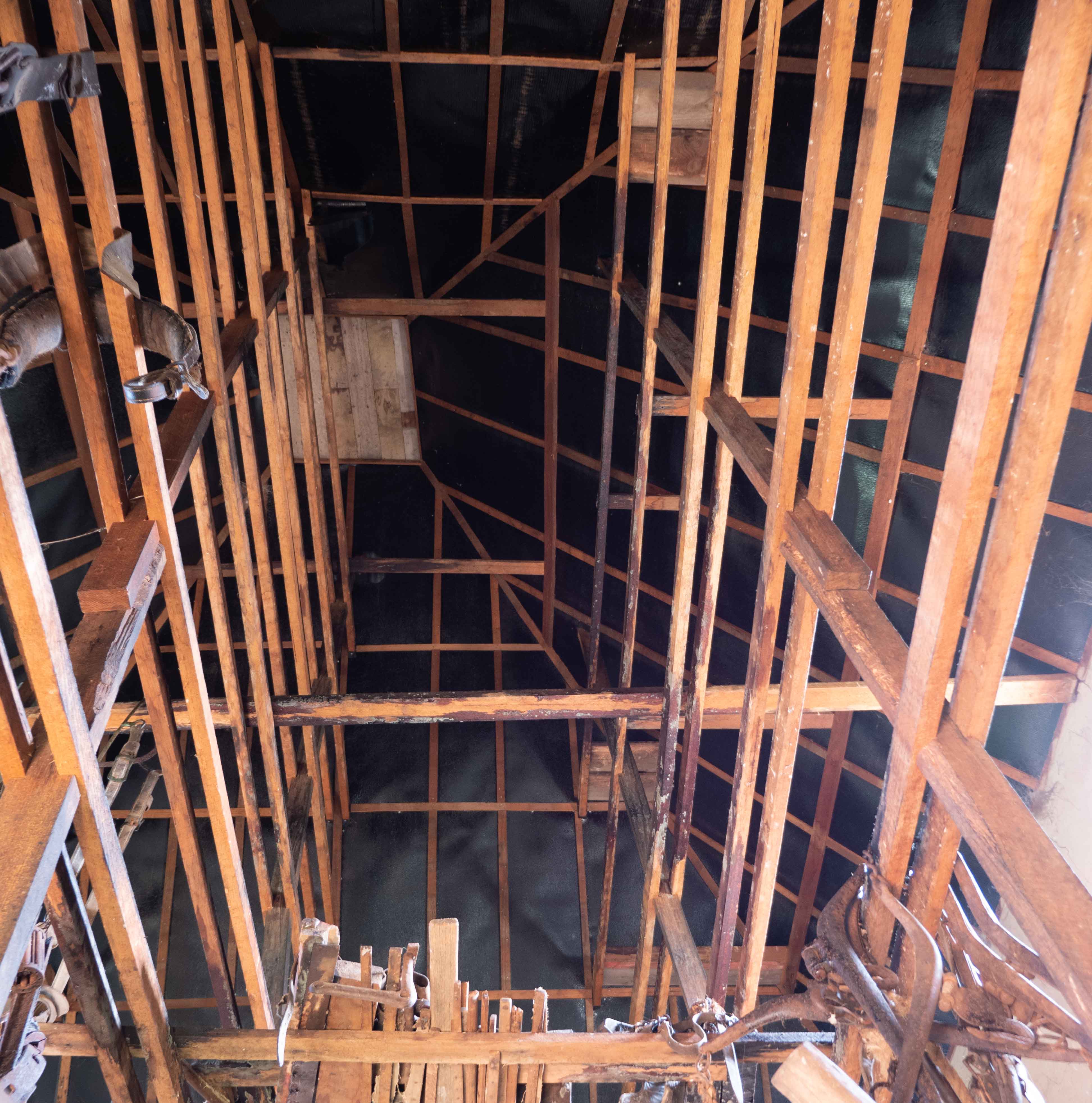 Numerous wooden beams inside the roof of an old building