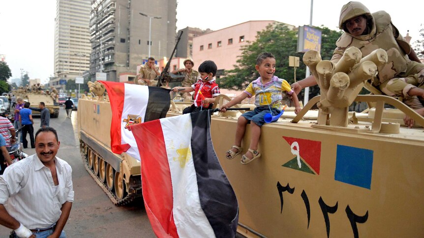 Children celebrate with Egyptian soldiers in a Cairo street.