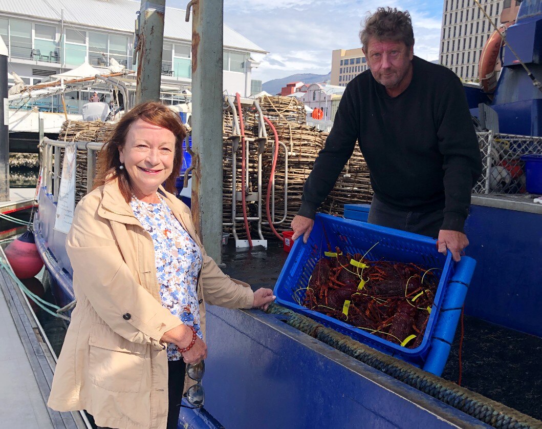 A woman buys crayfish straight off a boat 