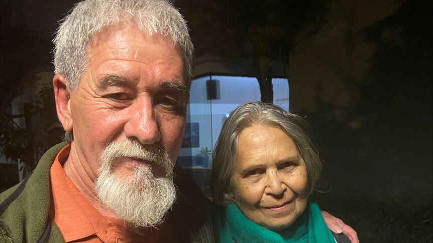 Two people with grey hair facing the camera