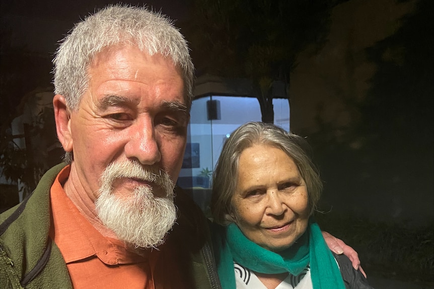 Two people with grey hair facing the camera