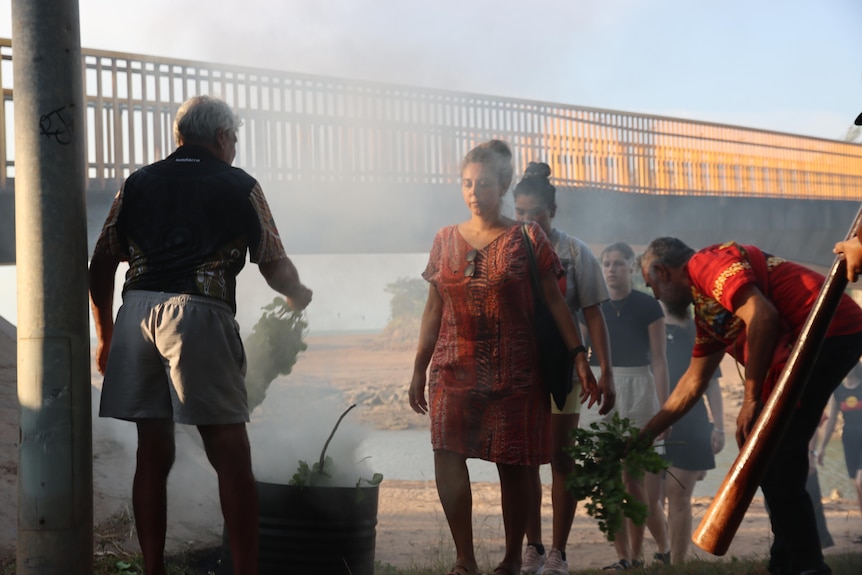 People taking part in a smoking ceremony.